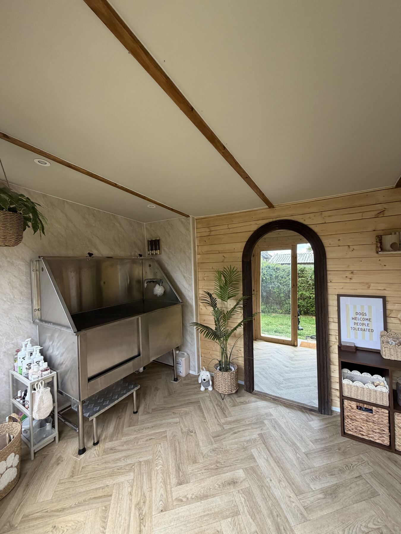 Bright interior of the cage-free grooming studio with arched door and herringbone floor